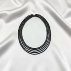 Flat lay of hematite necklace on white silk