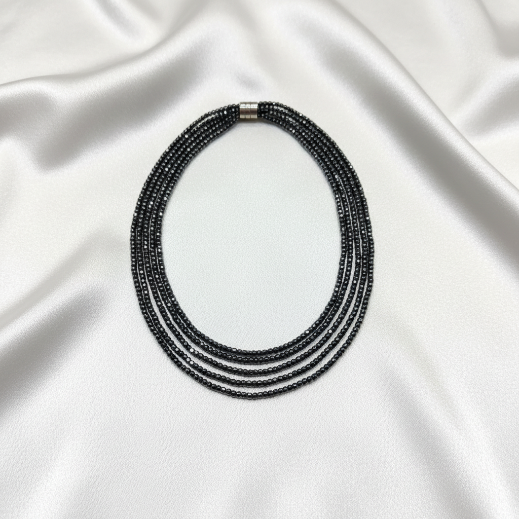 Flat lay of hematite necklace on white silk