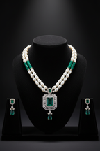 Pearl and teal AD pendant necklace set with earrings on dark velvet studio display