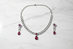 Ruby AD curb chain necklace set flat lay on white marble