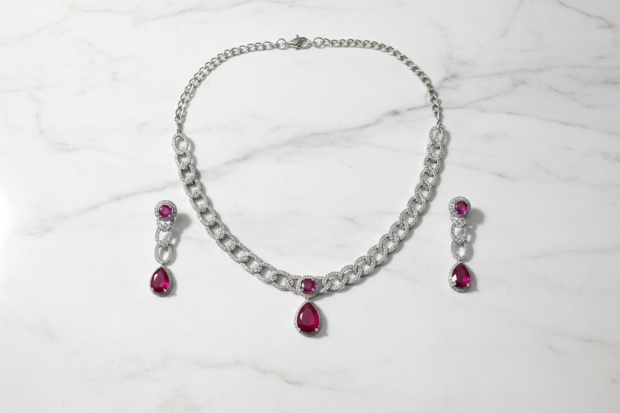 Ruby AD curb chain necklace set flat lay on white marble