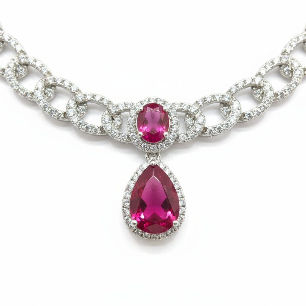 Close-up macro of AD curb chain links and ruby double-drop pendant