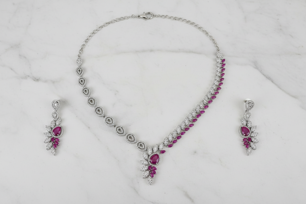 Pink ruby leaf AD necklace set flat lay on white marble