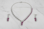 Pink ruby leaf AD necklace set flat lay on white marble