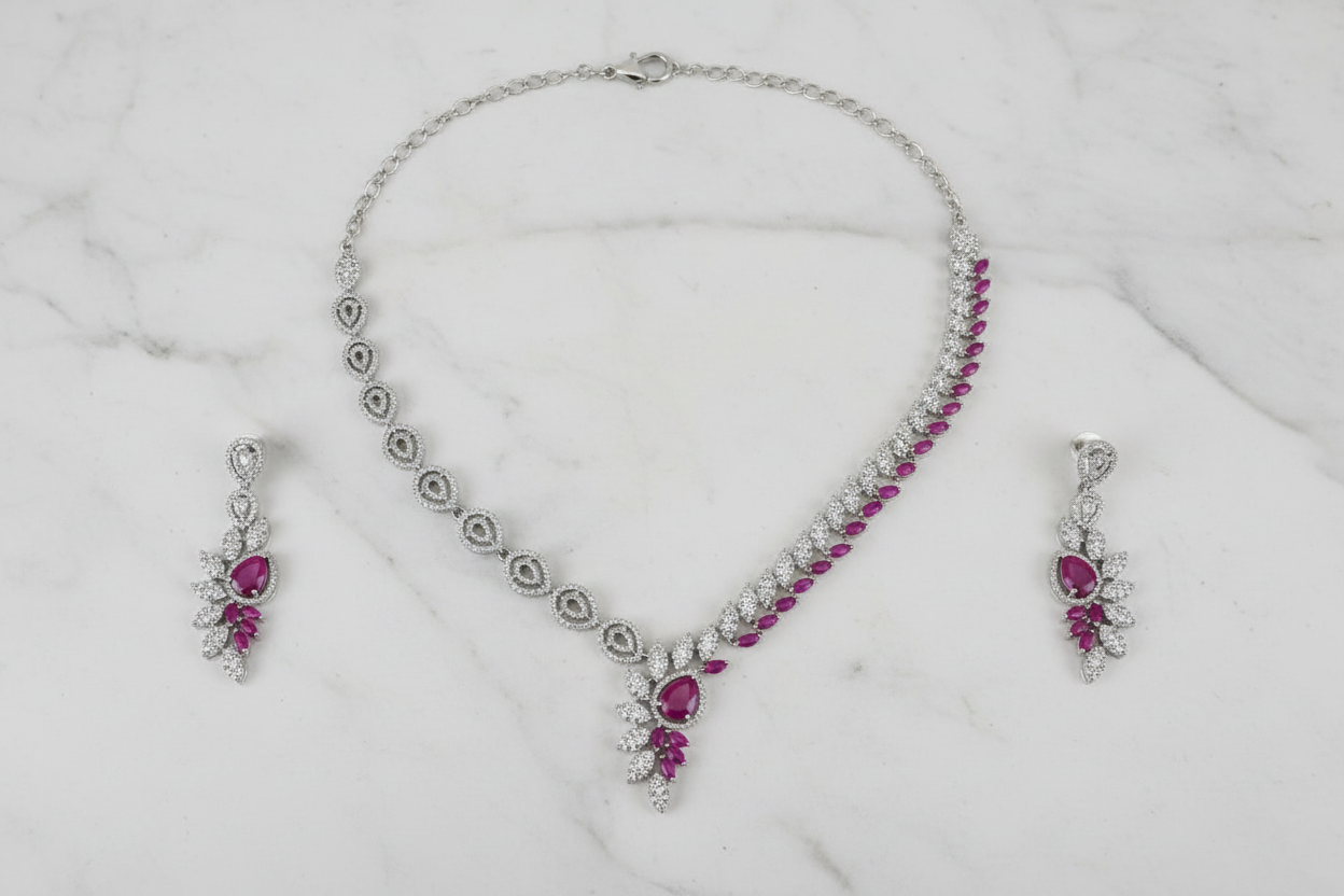 Pink ruby leaf AD necklace set flat lay on white marble
