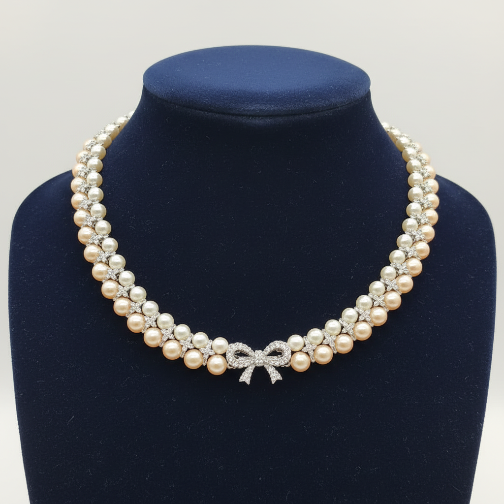 Double-strand champagne pearl and AD X-link necklace with bow clasp on navy velvet bust display