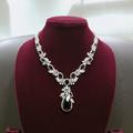 White AD and black onyx floral leaf pendant necklace set on burgundy velvet display