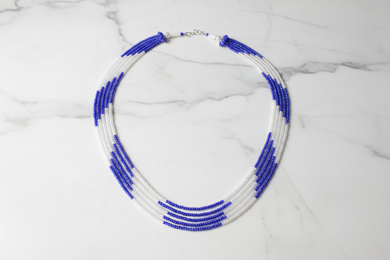Flat lay of blue and white seed bead necklace on white marble