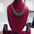 Emerald green double-row AD floral drop necklace set on burgundy velvet display