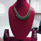 Emerald green double-row AD floral drop necklace set on burgundy velvet display