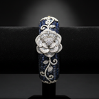 Navy blue sapphire baguette AD bangle with white floral AD sculpture on dark velvet studio display
