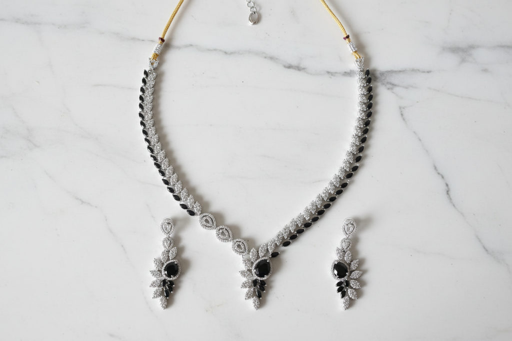 Black onyx leaf AD necklace set flat lay on white marble