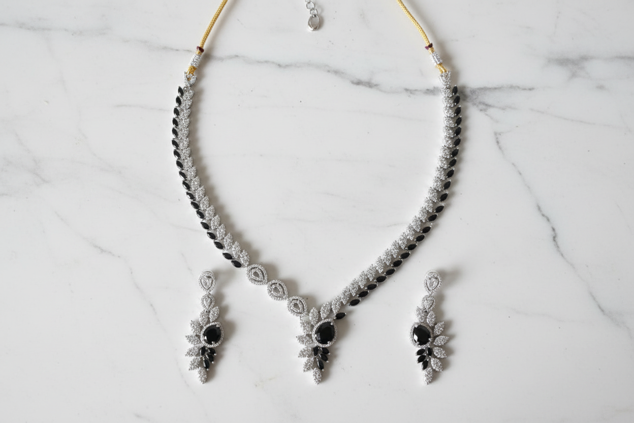 Black onyx leaf AD necklace set flat lay on white marble