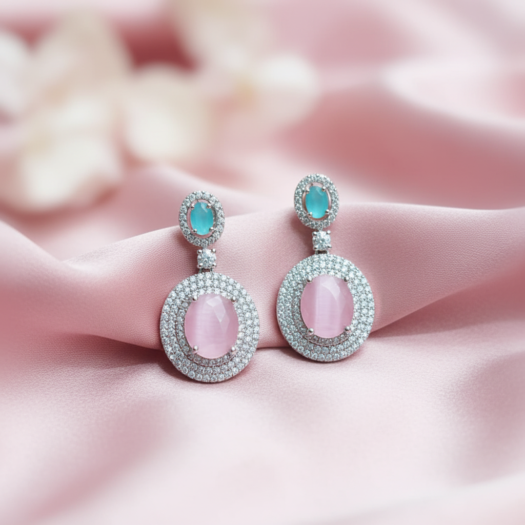 Pink cat's eye drop earrings on blush pink silk editorial flat lay