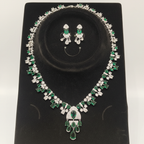 White AD and emerald green mixed-cut cluster graduated necklace set on black velvet display