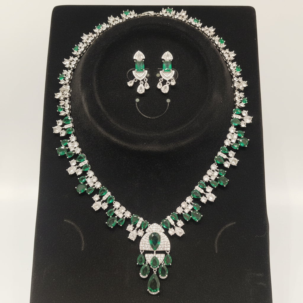 White AD and emerald green mixed-cut cluster graduated necklace set on black velvet display