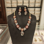 Ruby pink floral and jade green AD leaf necklace set on burgundy velvet display