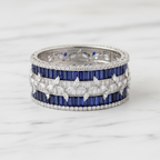 Flat lay top-down view of navy blue baguette AD bangle with white marquise leaf overlay on white marble