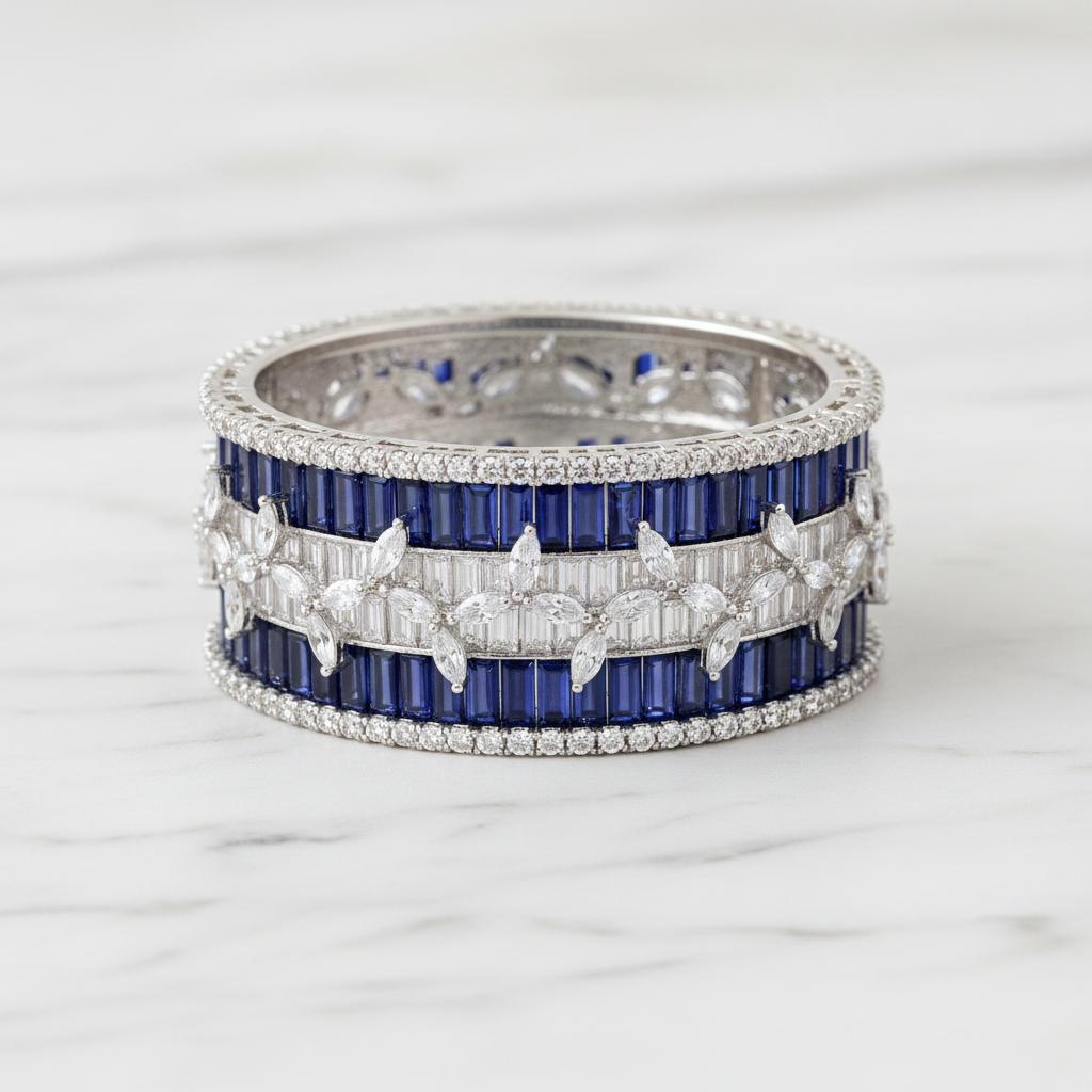 Flat lay top-down view of navy blue baguette AD bangle with white marquise leaf overlay on white marble