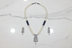 Flat lay of pearl and AD pendant necklace set with earrings on white marble