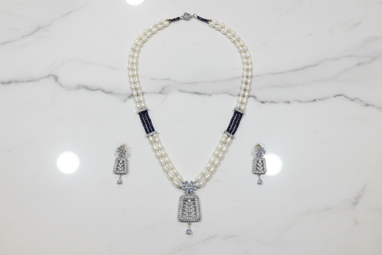 Flat lay of pearl and AD pendant necklace set with earrings on white marble