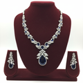 White AD and sapphire blue floral leaf pendant necklace set on burgundy velvet display