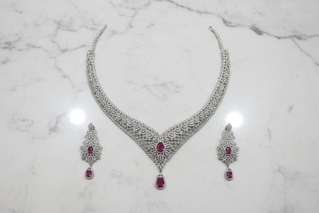 Ruby AD V-necklace set flat lay on white marble