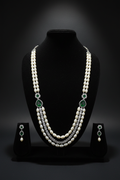 2-strand pearl long necklace with emerald AD stations on dark velvet studio display