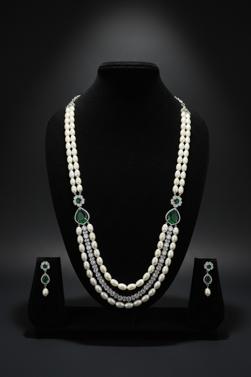 2-strand pearl long necklace with emerald AD stations on dark velvet studio display