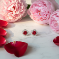 Ruby red CZ floral frame stud earrings on white marble with roses and peonies - romantic lifestyle style
