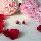 Ruby red CZ floral frame stud earrings on white marble with roses and peonies - romantic lifestyle style
