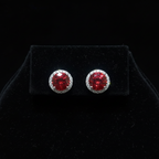 Ruby red CZ round halo stud earrings on black velvet - dark editorial style