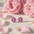Ruby pink CZ floral star stud earrings on white marble with rose petals and peonies - romantic lifestyle style
