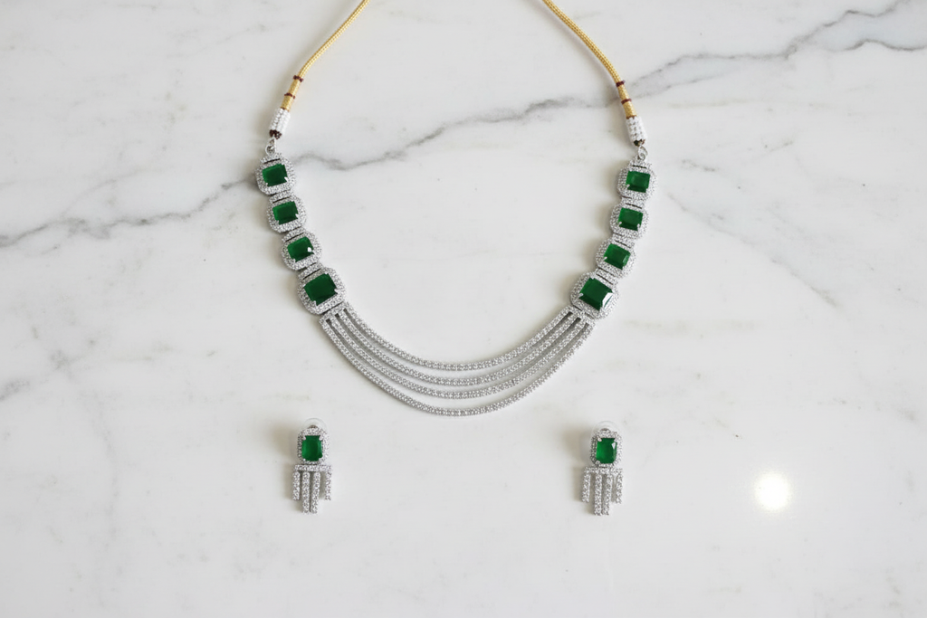 Emerald multi-strand AD necklace set flat lay on white marble