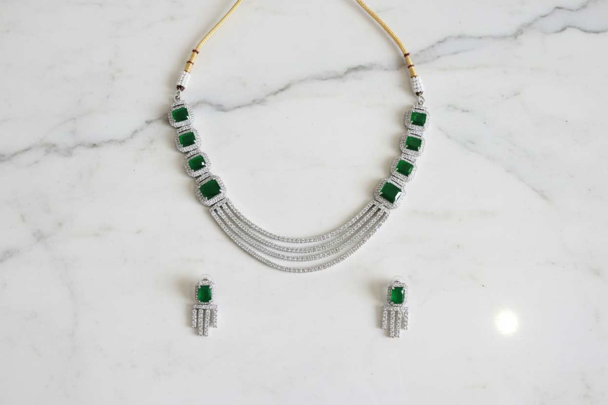 Emerald multi-strand AD necklace set flat lay on white marble