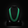 5-strand emerald green crystal bead necklace on dark velvet studio display