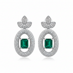 Emerald solitaire drop earrings on white background studio shot