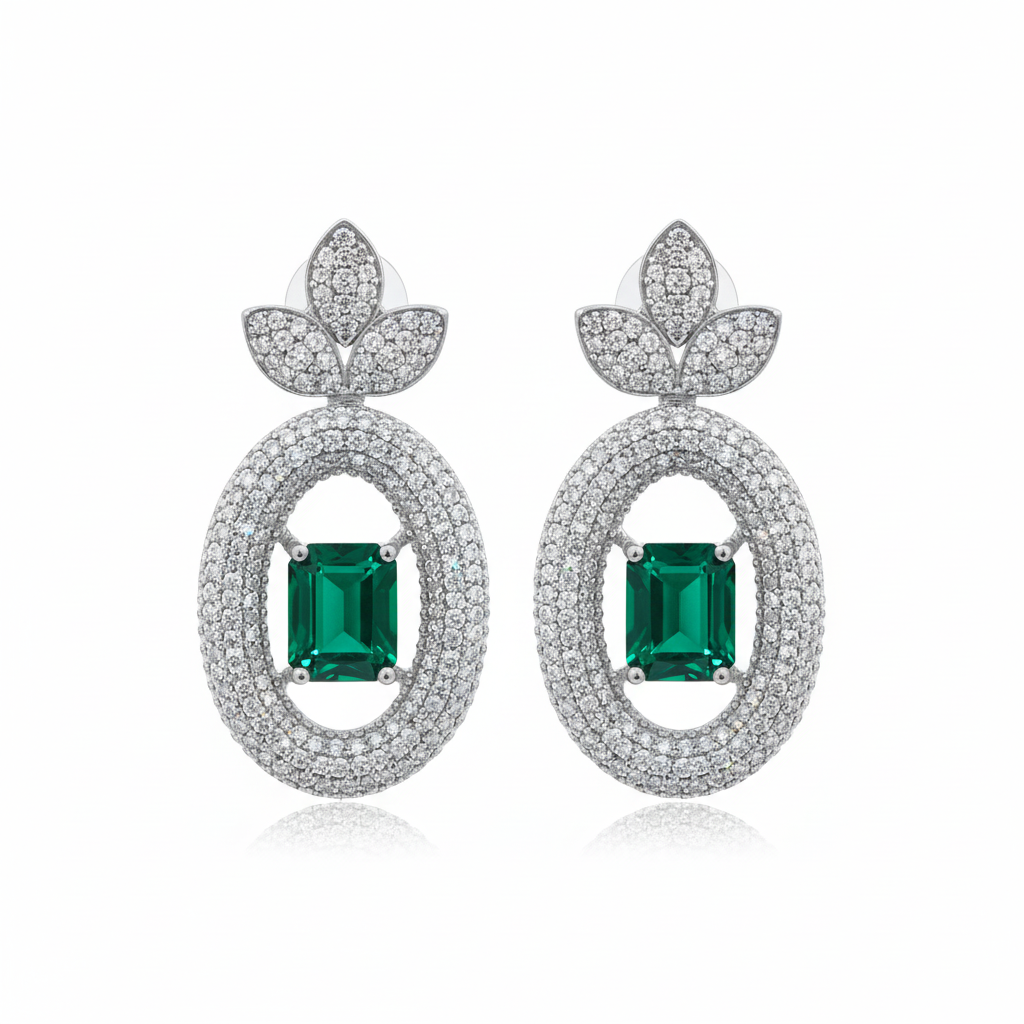 Emerald solitaire drop earrings on white background studio shot
