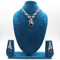White AD and garnet red floral leaf pendant necklace set on teal velvet display