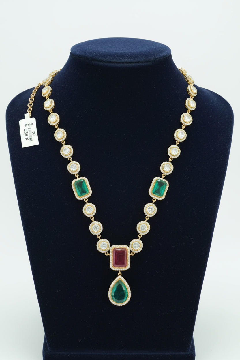 Polki-style gold AD necklace with emerald and ruby pendant drop on navy velvet display