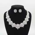 White AD multi-cut cluster graduated statement necklace set with stud earrings on black velvet display