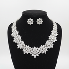 White AD multi-cut cluster graduated statement necklace set with stud earrings on black velvet display