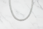Flat lay of white AD double-row tennis necklace on white marble