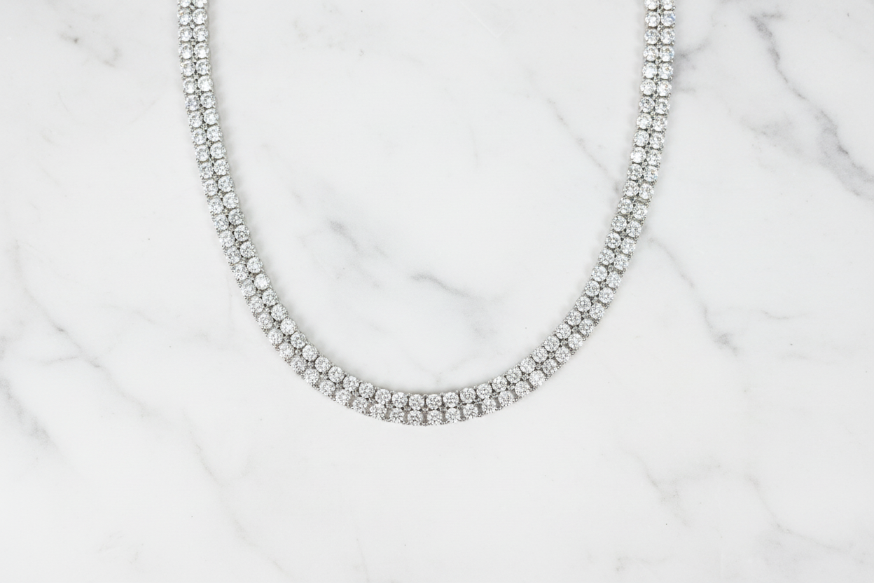 Flat lay of white AD double-row tennis necklace on white marble