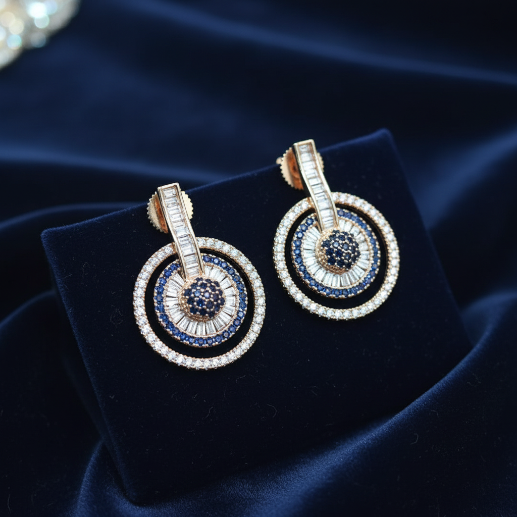 Sapphire blue circle drop earrings on navy velvet editorial flat lay
