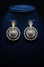 Rose gold diamond halo circle drop earrings on dark velvet display