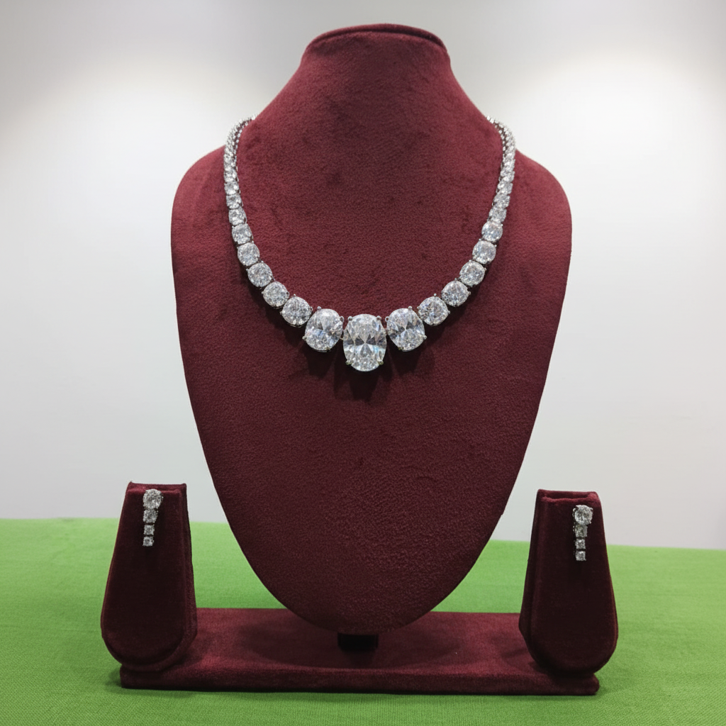 White AD mixed-cut graduated tennis necklace set with pear drop earrings on burgundy velvet display