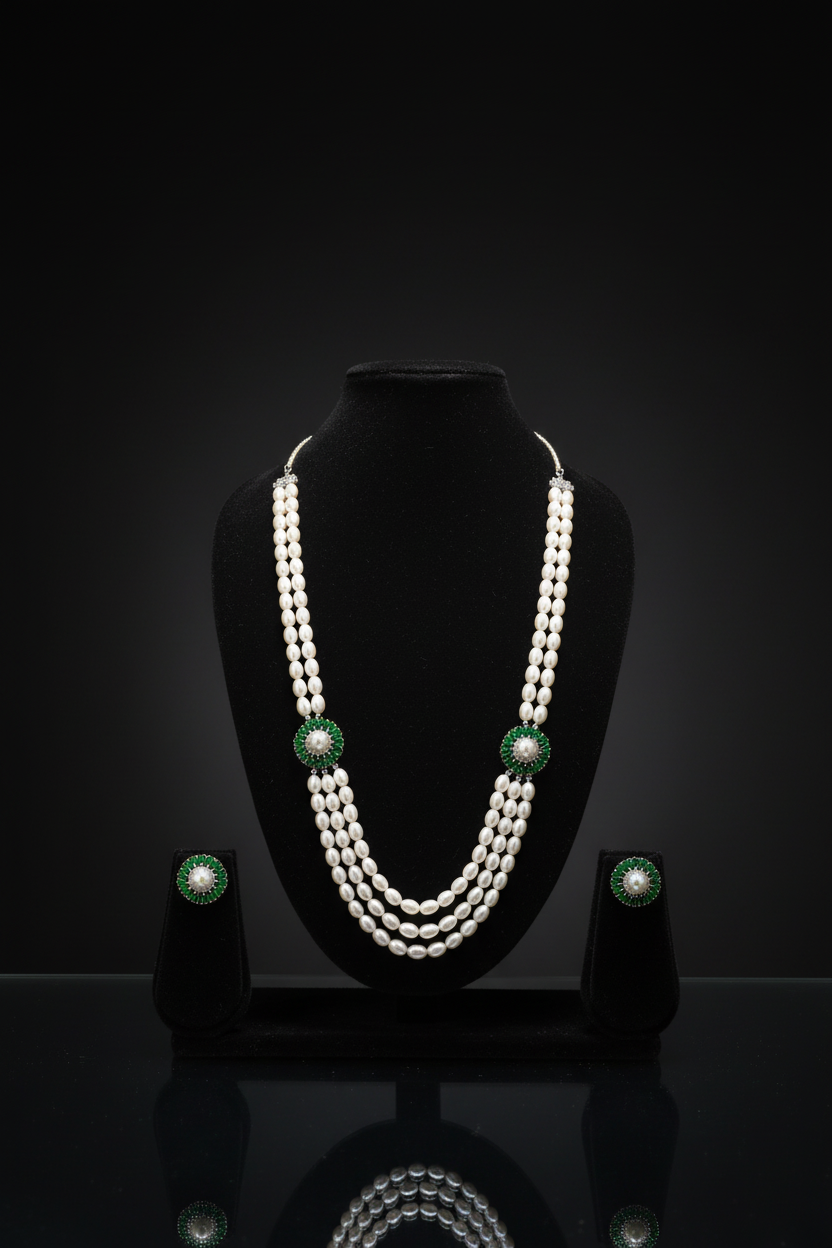 3-strand pearl long necklace with emerald floral AD stations on dark velvet studio display