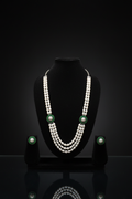 3-strand pearl long necklace with emerald floral AD stations on dark velvet studio display