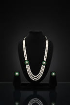 3-strand pearl long necklace with emerald floral AD stations on dark velvet studio display
